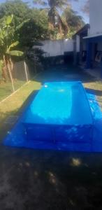 a blue pool in the yard of a house at Casa toda mobiliada in Iguaba Grande