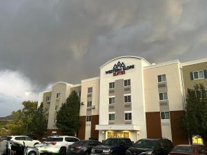 降落伞Western Slope Suites Parachute的一座大楼，停车场里停满了汽车