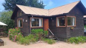 a small wooden house with a metal roof at Las Delicias in Maitencillo