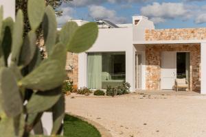 a white house with a cactus in front of it at Borgo Tufaia in Fasano