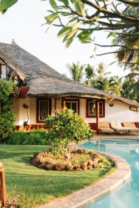 una casa con piscina delante de una casa en Villa Keur Koba, en Saly Portudal