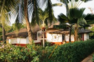 una casa con palmeras delante en Villa Keur Koba, en Saly Portudal