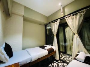 a bedroom with two beds and a window at Sulu Stay Inn Near Mumbai International Airport in Mumbai