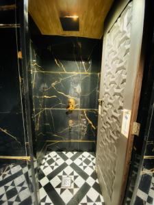 a bathroom with a black wall and a black and white tile floor at Sulu Stay Inn Near Mumbai International Airport in Mumbai +16 photos