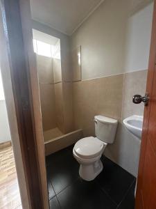 a bathroom with a toilet and a sink at Agora Hs in Chincha