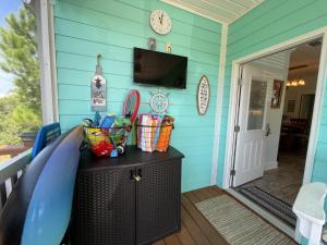 a front porch with a blue wall and a television at Rookery 7026 in Gulf Shores