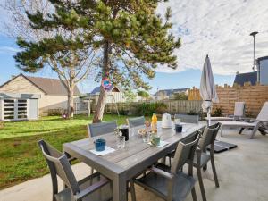 a wooden table and chairs on a patio with a tree at Holiday Home Lésaro by Interhome in Saint-Jean-de-la-Rivière