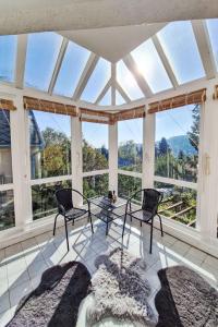 a conservatory with chairs and a table and windows at Apartment Bonika by Interhome in Fonyód