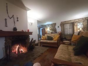 a living room with a fireplace and a couch at casa na aldeia - entre Fundão e Covilhã in Pêro Viseu