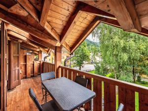 - un balcon en bois avec une table et des chaises dans l'établissement Apartment Balli by Interhome, à Pinzolo
