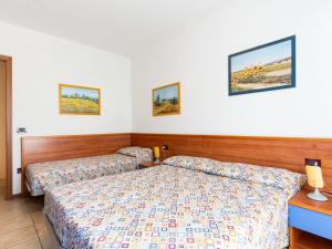 ein Hotelzimmer mit zwei Betten und zwei Lampen in der Unterkunft Holiday Home La Quercia-2 by Interhome in La Fagiana