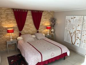 a bedroom with a large bed with red curtains at Le Moulin de Mayence in Plazac