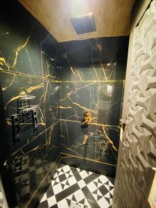 a bathroom with a black and white tiled wall at Sulu Stay Inn Near Mumbai International Airport in Mumbai