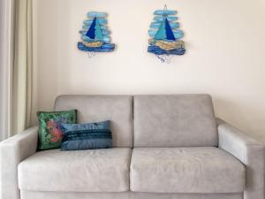 a living room with a couch and blue plates on the wall at Apartment La terrazza sulla piscina by Interhome in Valledoria +42 photos