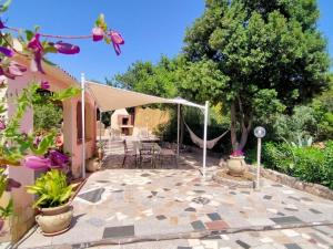 une terrasse avec une tente, des chaises et des arbres dans l'établissement Villa Doxina by Interhome, à Solanas
