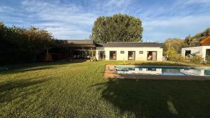 a house with a pool in front of a yard at Cabaña independiente Quillón in Chillancito