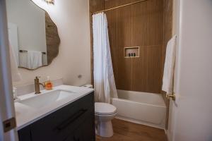 a bathroom with a sink and a toilet and a mirror at Terracotta Suite at ArnoTriplex! Hot Tub and Pet Friendly! in Albuquerque +26 photos