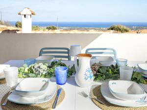 a table with blue and white dishes and a vase at Holiday Home La Conchiglia D'oro by Interhome in Budoni