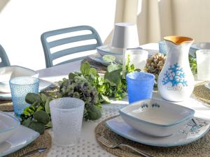a table with blue and white plates and vases on it at Holiday Home La Conchiglia D'oro by Interhome in Budoni