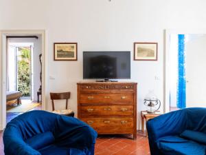 a living room with a tv and a dresser with a television at Apartment Casa del Capitano by Interhome in San Bartolomeo al Mare