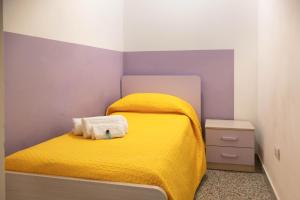 une petite chambre avec un lit jaune avec une couverture jaune dans l'établissement La casa di Francesca, à Matera
