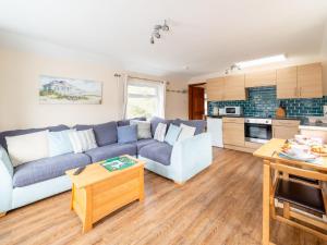 メバギシーにあるApartment Harbourside Hideaway by Interhomeの青いソファとキッチンのあるリビングルーム