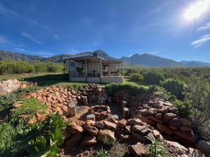 ein Haus mit einem Haufen Steine davor in der Unterkunft Renewal Retreat Klein Karoo Cottage in Uniondale