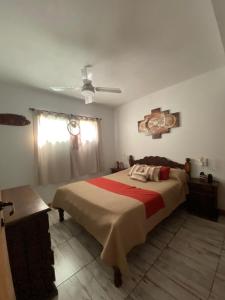 a bedroom with a large bed and a ceiling fan at Cabañas Vicentico in Mina Clavero