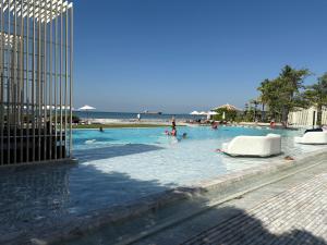 a large swimming pool with people in the water at 芭提雅日瓦达酒店式公寓 in Na Jomtien