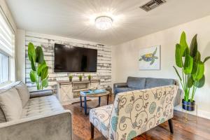 a living room with a couch and a tv at Oasis with Heated Pool 5 Mi to Anclote Gulf Park! in Holiday
