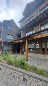 ein großes Gebäude mit einigen Pflanzen davor in der Unterkunft Blizu II in Villa La Angostura