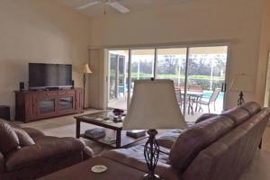 a living room with a couch and a television at Sunny Breezes Villa in Placida