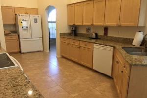 a kitchen with wooden cabinets and a white refrigerator at Sunny Breezes Villa in Placida