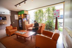a man sitting on a couch in a waiting room at Centro by Casa Andina Miraflores in Lima +38 photos
