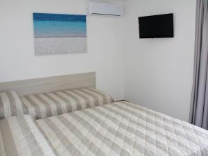 Apartment Nashira-6 by Interhome في لينانو سابيادورو: غرفة نوم بها سرير وتلفزيون على الحائط