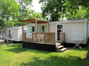 a mobile home with a porch and a deck at Holiday Home Happy Premium by Interhome in Rosapineta