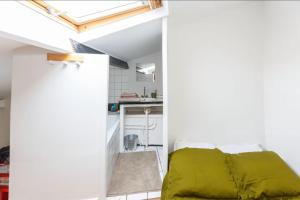 巴黎Votre suite entre Belleville et Canal的一间小卧室,房间内设有一张绿色的床