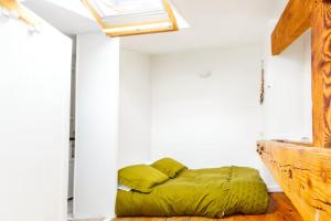 巴黎Votre suite entre Belleville et Canal的一间设有一张绿色床的卧室,位于一个设有窗户的房间