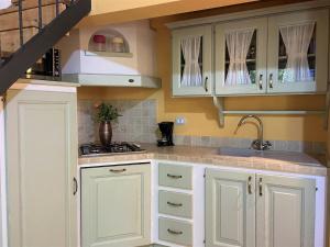 Una cocina con gabinetes blancos y un fregadero. en Apartment Istrice-30 by Interhome, en Riparbella 34 fotos más
