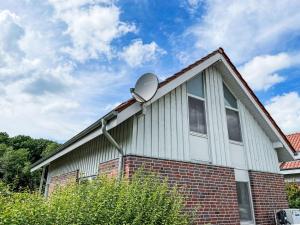 a house with a satellite dish on the side of it at Holiday Home Müritz Ferienpark Röbel-51 by Interhome in Röbel