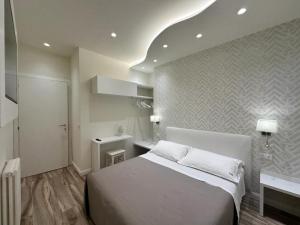 a bedroom with a white bed and a sink at Ines Apartments in Giardini Naxos