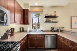 a kitchen with wooden cabinets and a counter top at Picturesque 1BR in Legacy Villas near Main Pool #A in La Quinta