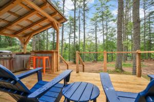a deck with blue chairs and a table and a stove at A-Frame Retreat with Inviting Hot Tub in Oxford