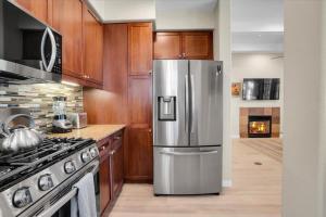a kitchen with a stainless steel refrigerator and a stove at Modern LQ Getaway Steps to pool & spa #A in La Quinta