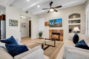 a living room with a couch and a fireplace at Modern LQ 3BR Getaway Steps to pool & spa in La Quinta
