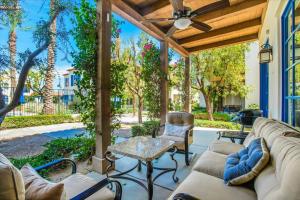 a patio with a couch and chairs and a ceiling fan at Modern LQ 3BR Getaway Steps to pool & spa in La Quinta