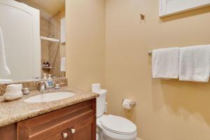 a bathroom with a white toilet and a sink at Desert Oasis Villa #A Steps from Pool in La Quinta