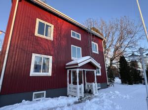 a red house with snow on the side of it at Entire Apartment 50 sqm Modern & Free Parking in Umeå