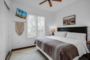 a bedroom with a bed with a ceiling fan and a window at Revitalized Desert Getaway #A in La Quinta
