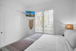 a white bedroom with a bed and a window at Revitalized Desert Getaway #A in La Quinta +24 photos